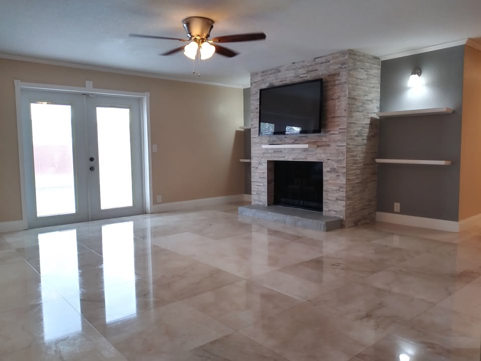 Clean polished tile floor and restored fireplace in a finished living room