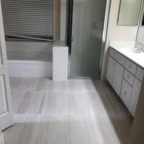 Clean bathroom with light tile flooring and vanity